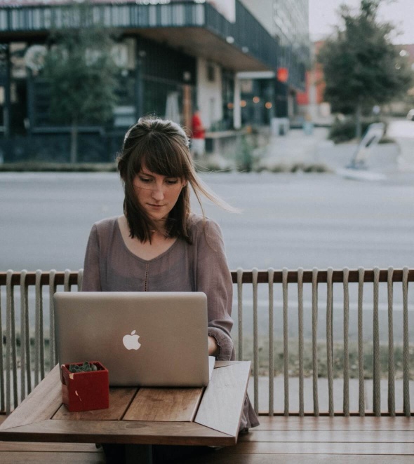 Woman sitting outside working on laptop